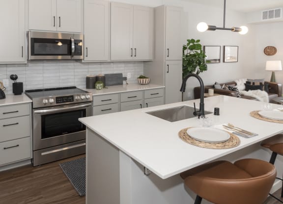 a kitchen with white cabinets and stainless steel appliances