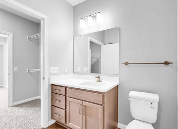 A white toilet sits next to a sink in a bathroom.