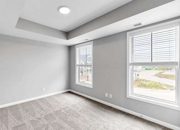 A room with a window showing a view of a street.
