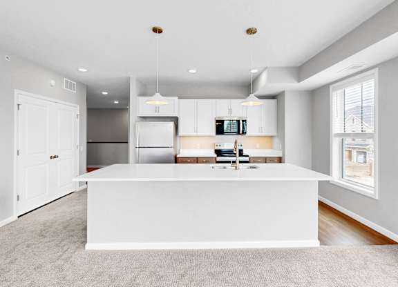 A modern kitchen with a white island in the middle.
