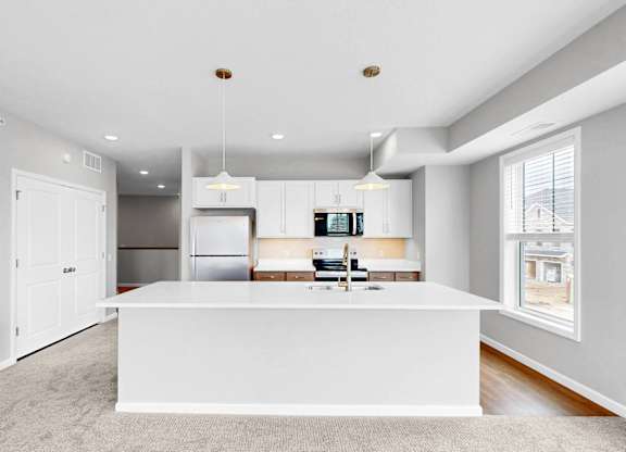 A modern kitchen with white cabinets and a large island.