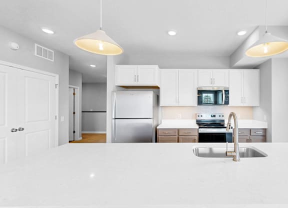 A modern kitchen with white cabinets and appliances.
