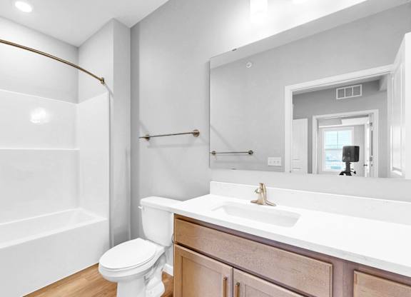 A white bathroom with a toilet, sink, and bathtub.
