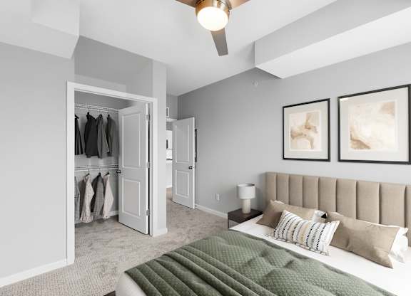 A bedroom with a bed, a ceiling fan, and two framed pictures on the wall.
