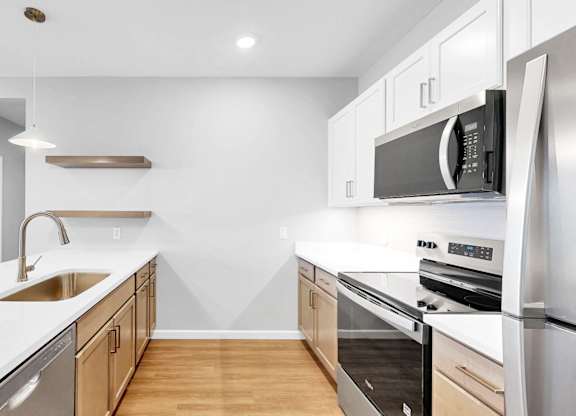 A modern kitchen with stainless steel appliances and wooden cabinets.