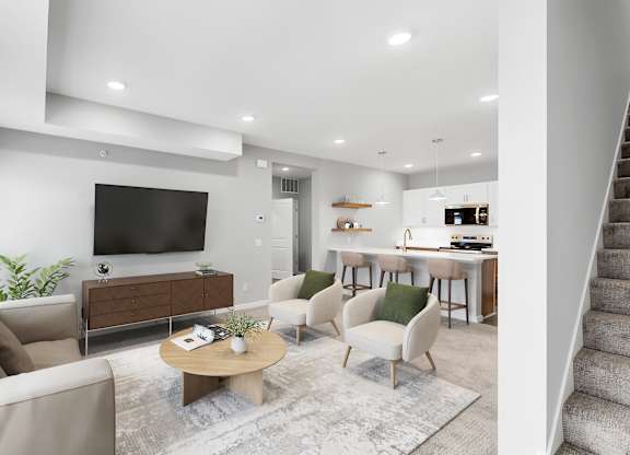 A modern living room with a large flat screen TV, a sofa, a coffee table, and a staircase.