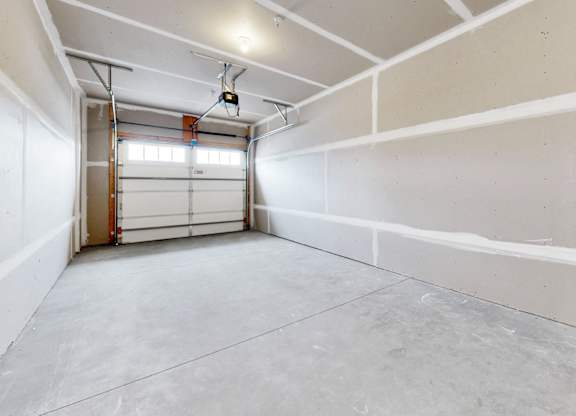 A large empty room with a door on the left side.