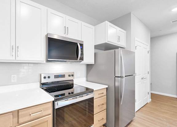 A kitchen with white cabinets and stainless steel appliances.