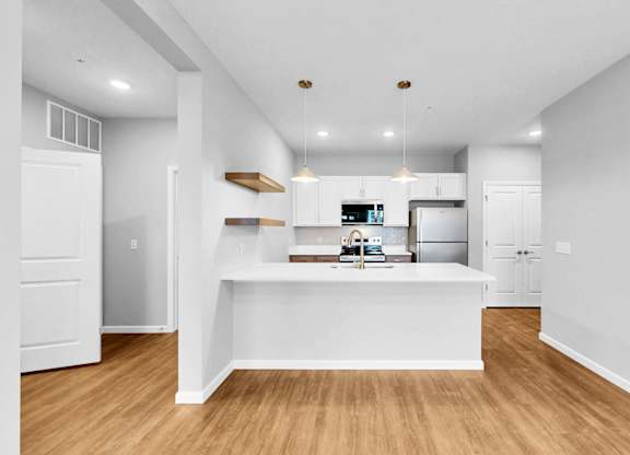 A kitchen with white cabinets and a wooden island.
