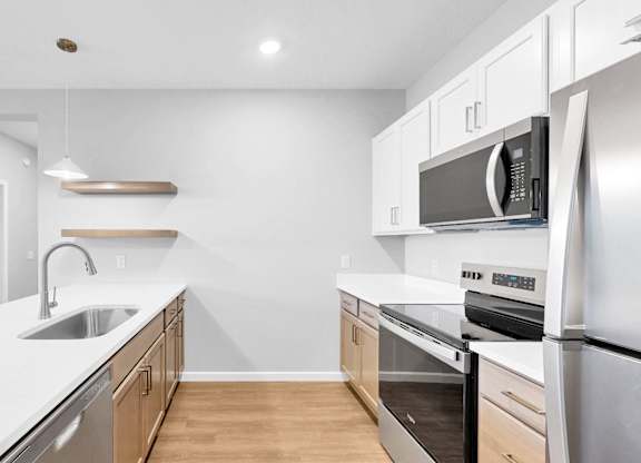 A modern kitchen with stainless steel appliances and wooden cabinets.