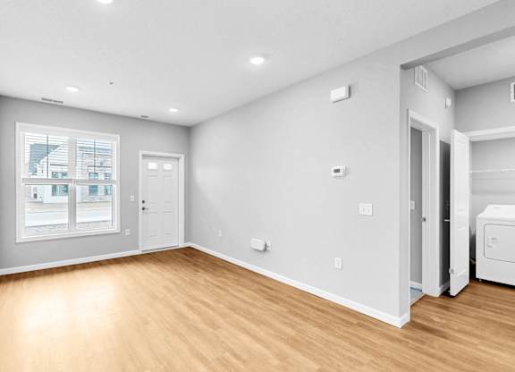 A room with a window, a door, and a wall socket.
