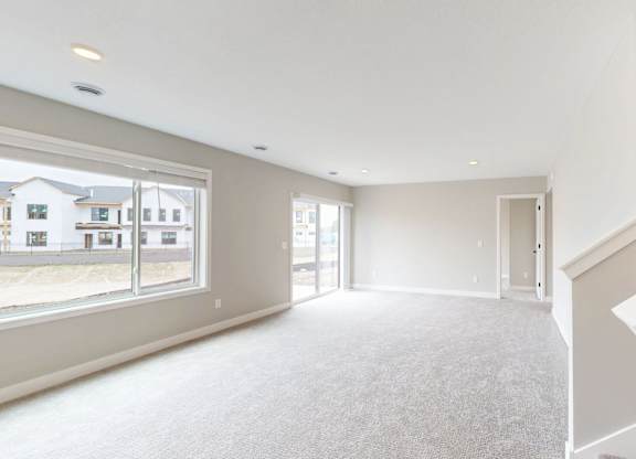 Spacious living room with carpeting and staircase at Wildwood Lakeville Apartments, Lakeville, MN 55044