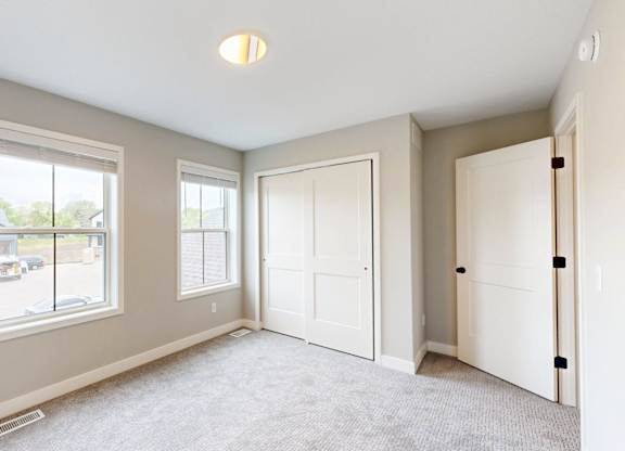 Carpeted bedroom with closet and alcove at Wildwood Lakeville Apartments, Lakeville, MN 55044