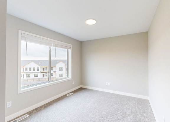 Bright empty bedroom with double window at Wildwood Lakeville Apartments, Lakeville