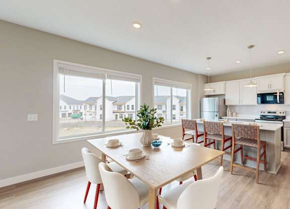 Dining room with table seating and kitchen island at Wildwood Lakeville Apartments, Minnesota, 55044