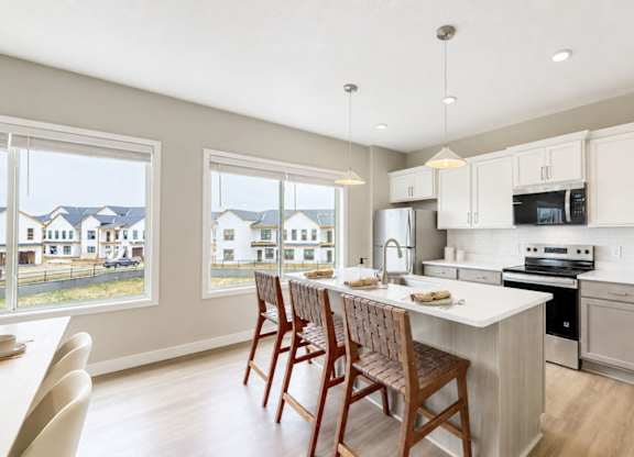 Modern kitchen with island and two pendant lights at Wildwood Lakeville Apartments, Lakeville, MN 55044