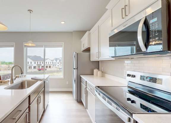 Galley kitchen with stainless steel appliances and white countertops at Wildwood Lakeville Apartments, Lakeville, 55044