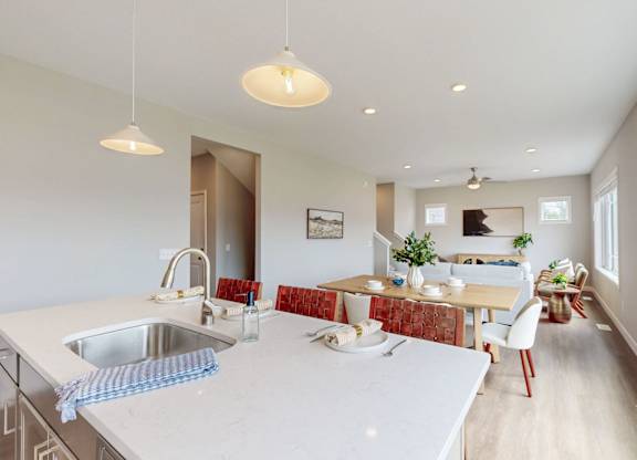 Open kitchen with island and dining space at Wildwood Lakeville Apartments, Minnesota