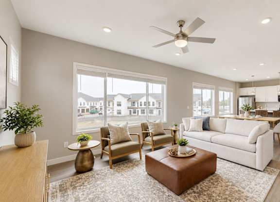Spacious living room with modern furnishings and ceiling fan at Wildwood Lakeville Apartments, Lakeville, MN