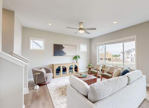 Living room with neutral tones and large window at Wildwood Lakeville Apartments, Lakeville