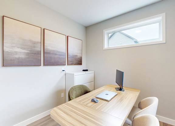 Home office with wood desk and wall art at Wildwood Lakeville Apartments, Minnesota, 55044