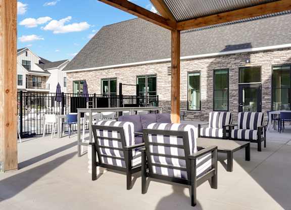 A patio with black and white striped chairs and a wooden pole.