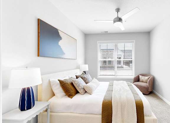A bedroom with a bed, a chair, and a painting on the wall.