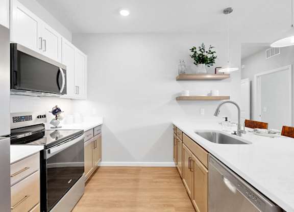 A modern kitchen with stainless steel appliances and wooden cabinets.