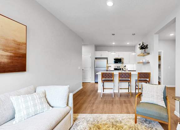 A living room with a couch, chairs, and a dining table.