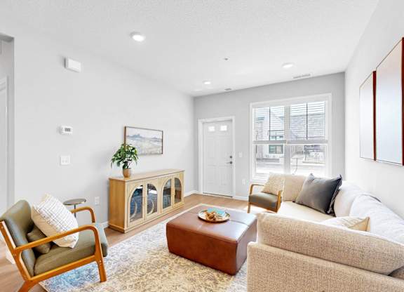 A living room with a chair, couch, and a table.