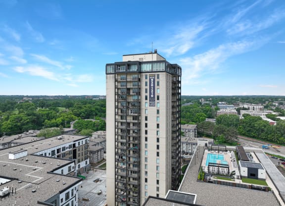an aerial view of a tall building with a pool in front of it