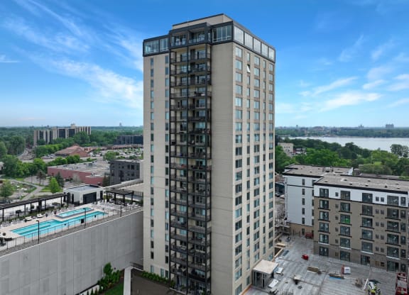 an aerial view of a tall building with a pool in front of it