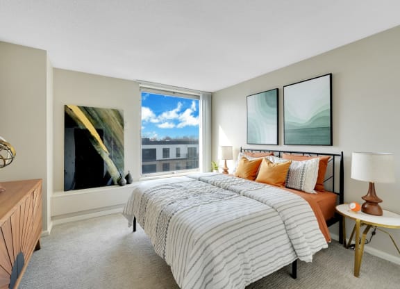 a bedroom with a bed and a large window