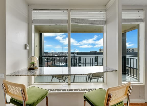 a living room with a large window and a table with chairs