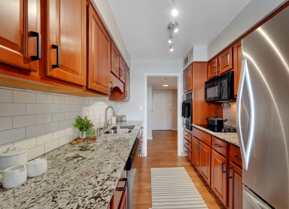 a kitchen with granite counter tops and wooden cabinets