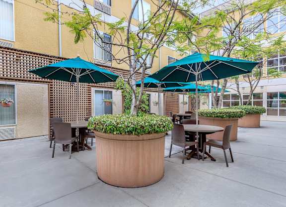 A Patio With Tables And Umbrellas at Atrium Garden Apartment Homes, LLC, San Jose, California