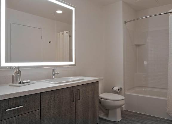 A bathroom with a white sink, toilet, and bathtub at Catalyst Mountain View, Mountain View, CA
