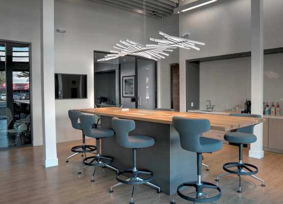 A modern kitchen with a long island and grey chairs at Catalyst Mountain View, Mountain View, CA