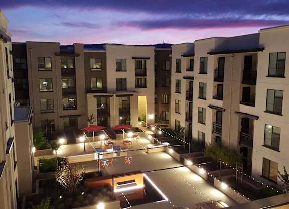 A courtyard surrounded by apartment buildings at dusk at Catalyst Mountain View, Mountain View
