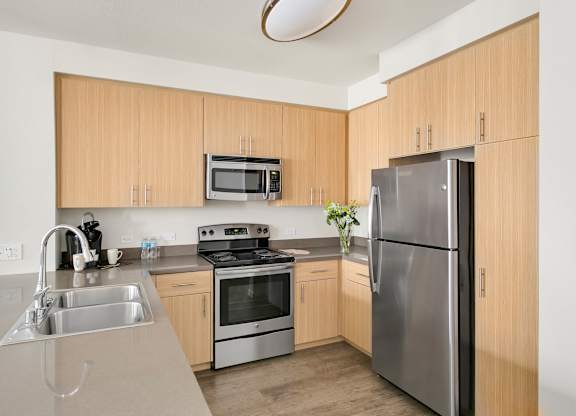 A kitchen with a refrigerator, sink, and oven. at Cirrus Redwood City Apartments, Redwood City, California