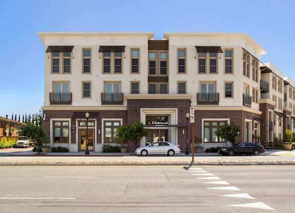 A street view of a building with cars parked in front. at Cirrus Redwood City Apartments, Redwood City, California