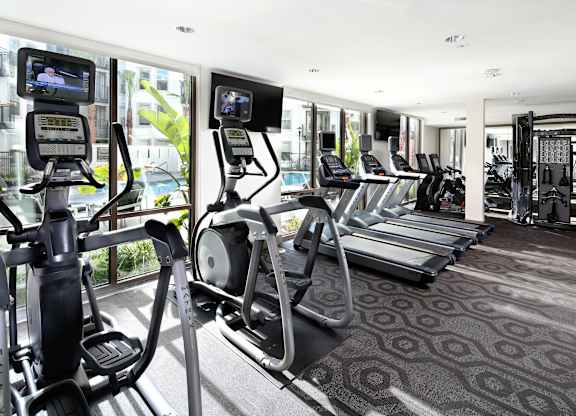 A gym with treadmills and elliptical machines. at Cirrus Redwood City Apartments, Redwood City, CA, 94061