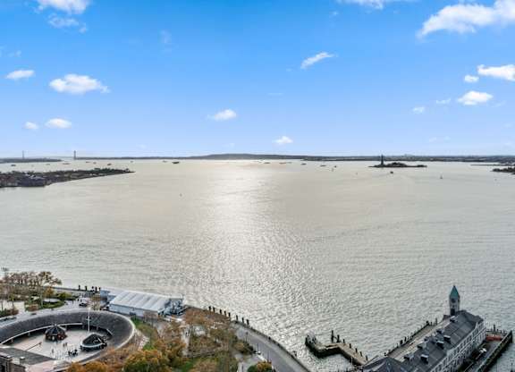 A large body of water with a building and a pier in the distance at One West, New York.