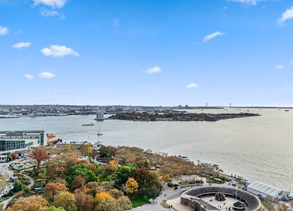 A view of a city with a large body of water and a bridge in the distance at Aria, New York, New York.