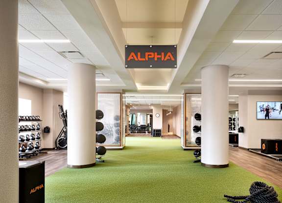 A gym with a green floor and a sign that says at One West, New York, New York
