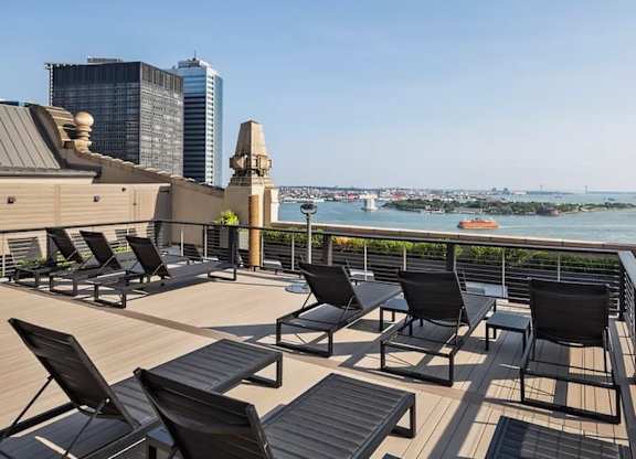 A balcony with black chairs and a view of the city. at One West, New York