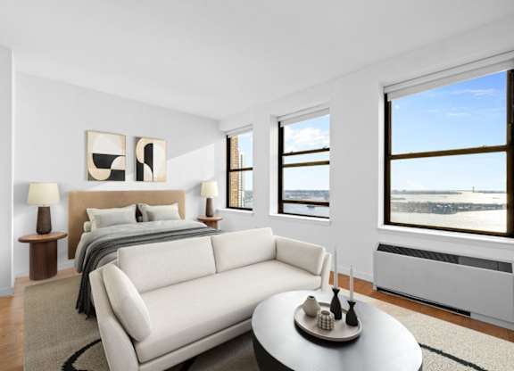 A bedroom with a large bed and a couch. at One West,New York, NY