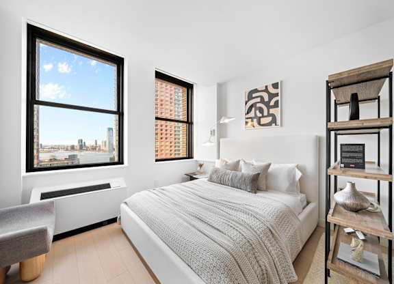 A bedroom with a large bed and a view of the city at One West,  New York,10004.