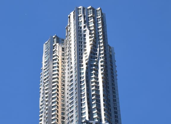 A tall building with many windows and balconies reaches into the sky at Aria, New York, NY