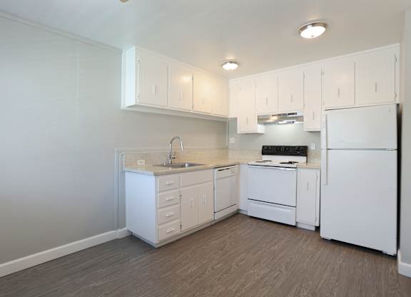 A kitchen with white appliances and cabinets.
